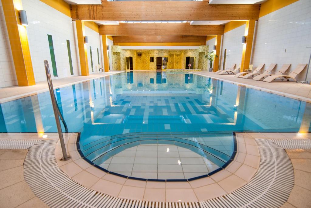- une grande piscine d'eau bleue dans un bâtiment dans l'établissement Medical SPA "Eglės sanatorija" Standard Druskininkai, à Druskininkai