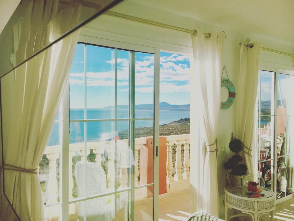 a room with a balcony with a view of the ocean at Playa Paraiso DolceVita in Costa Calma