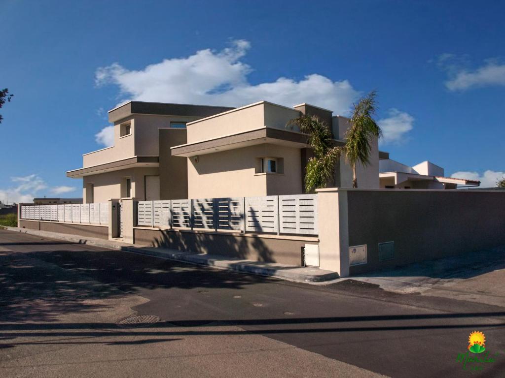 un edificio bianco con una recinzione di fronte di Marilù B&B a Matino