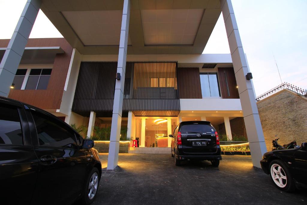 a car parked in a parking lot in front of a building at Vinotel Cirebon in Cirebon