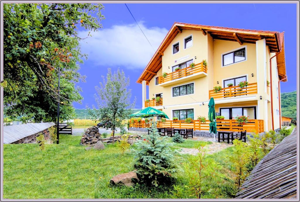 a building with tables and chairs in front of it at Camves Inn in Sighetu Marmaţiei