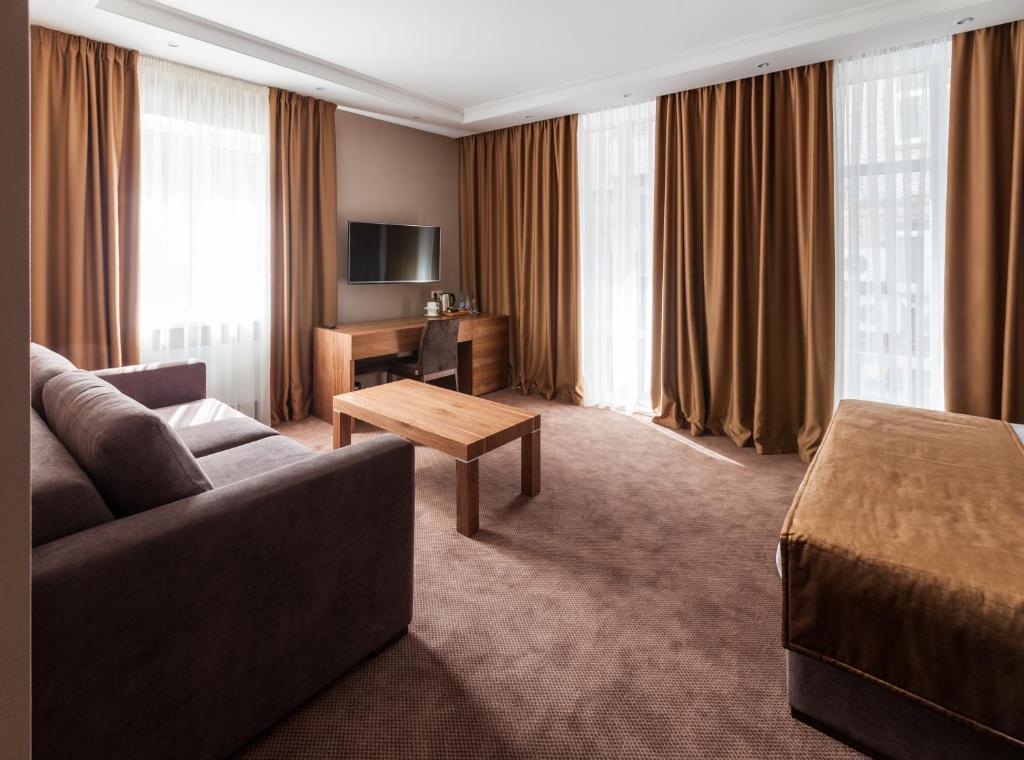 una camera d'albergo con divano e tavolo di Crystal Hotel a Kiev