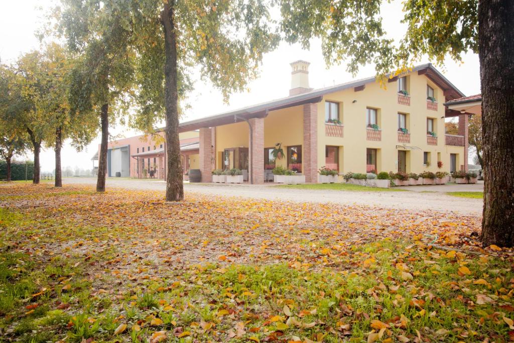 a building with trees and leaves on the ground at Agriturismo Pituello in Talmassons