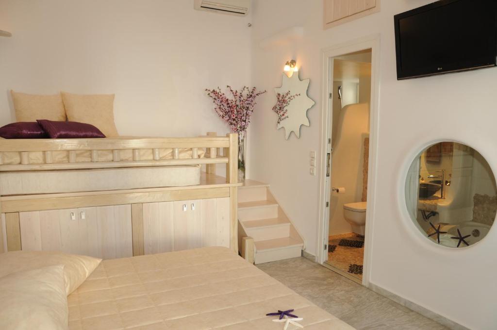 a bedroom with a bunk bed and a mirror at Starlight Luxury Studios in Mikonos