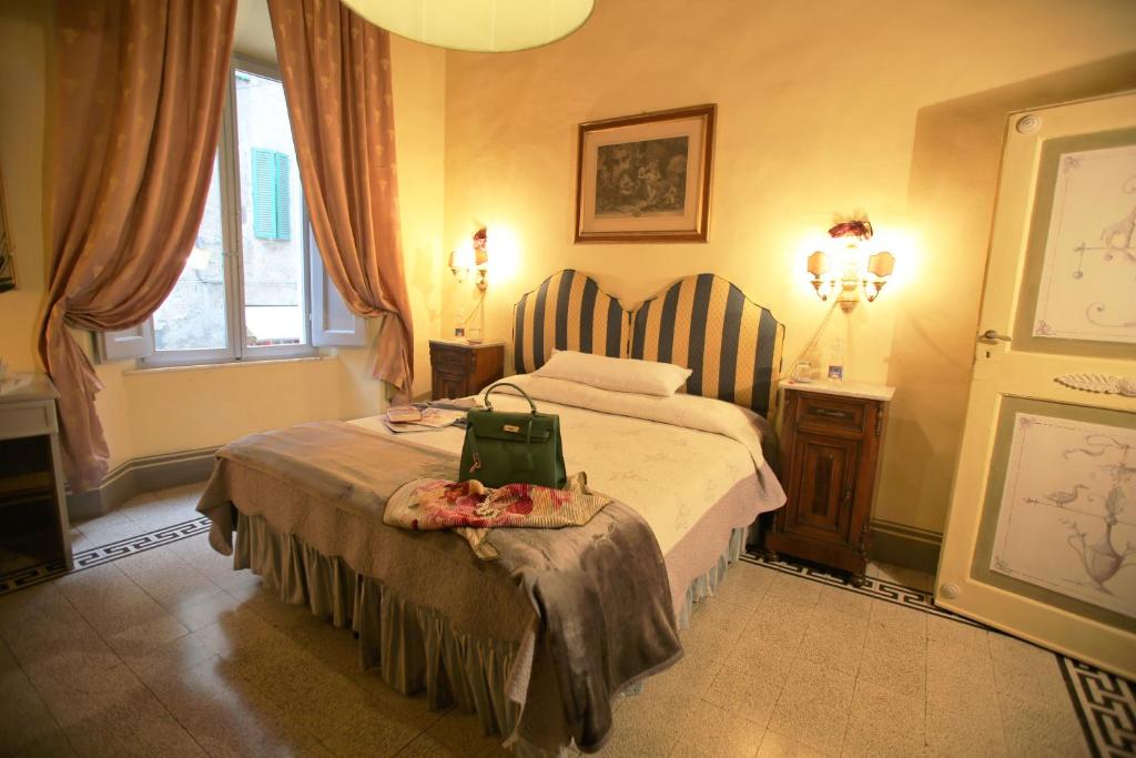 a bedroom with a bed with a green bag on it at B&B Le Aquile in Siena