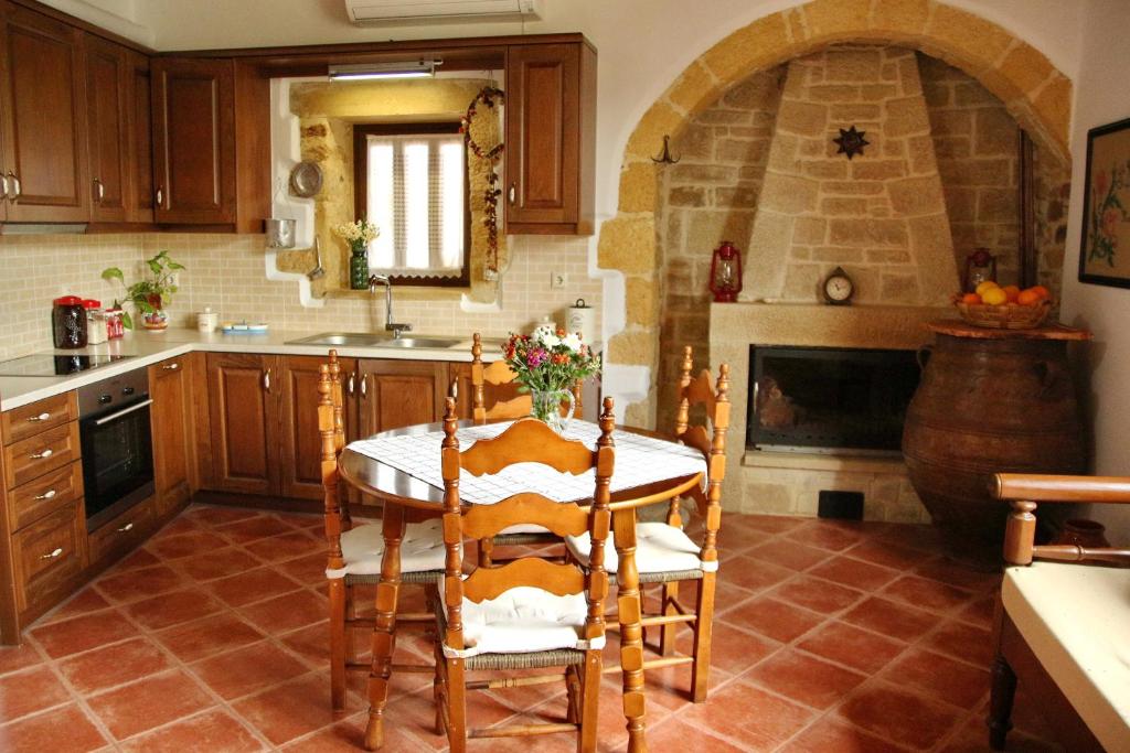 a kitchen with a table and a fireplace at Fudulis Villa in Ravdhoúkha