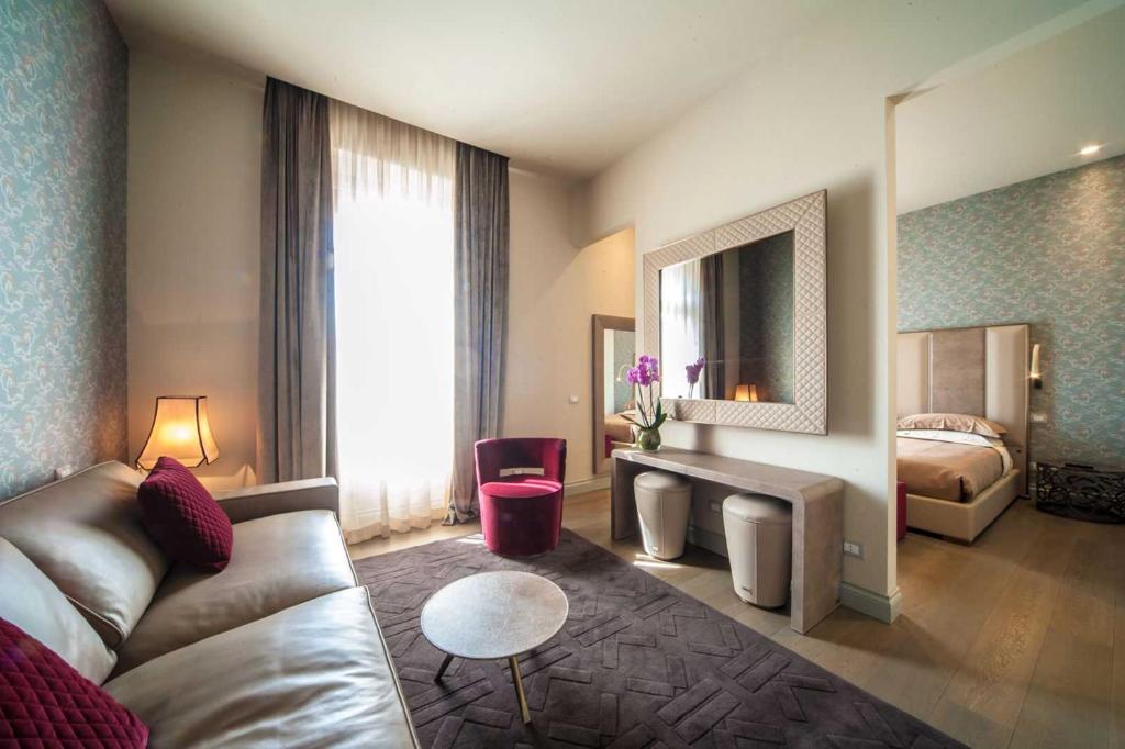 ローマにあるヴィットリアノ ラグジュアリー スイートのソファとベッド付きのホテルルーム