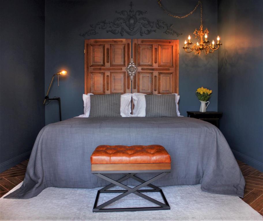 Boutique Hotel Apsuana Rose في غاغرا: غرفة نوم بسرير كبير مع اللوح الخشبي