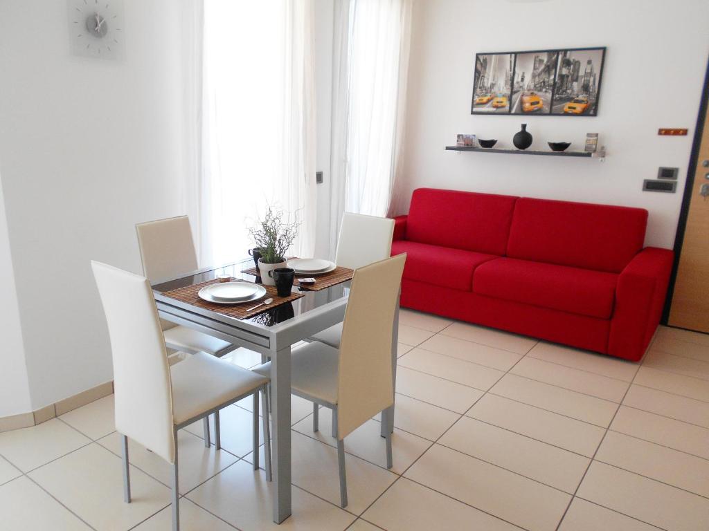 a living room with a red couch and a table and chairs at La trifula bianca apts. in Alba