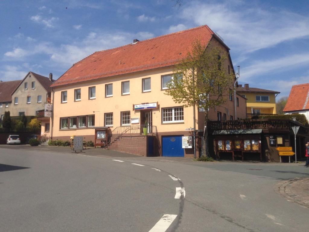 a building with a red roof on a street at Sauerland-Hotel in Essentho