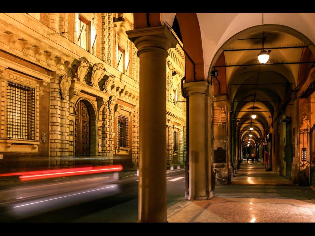 ein Gebäude mit Säulen und einer Spielhalle mit einem Auto in der Unterkunft TL Palazzo Fantuzzi in Bologna