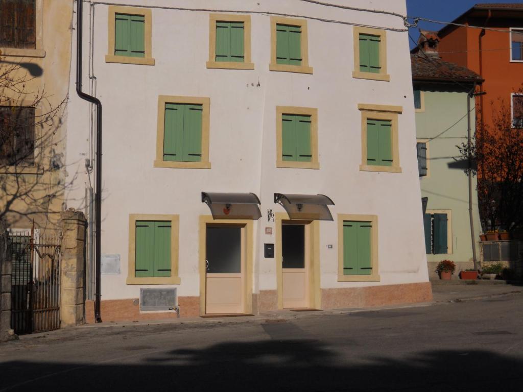 a building with green and yellow doors on a street at Piccolo Borgo in Negrar