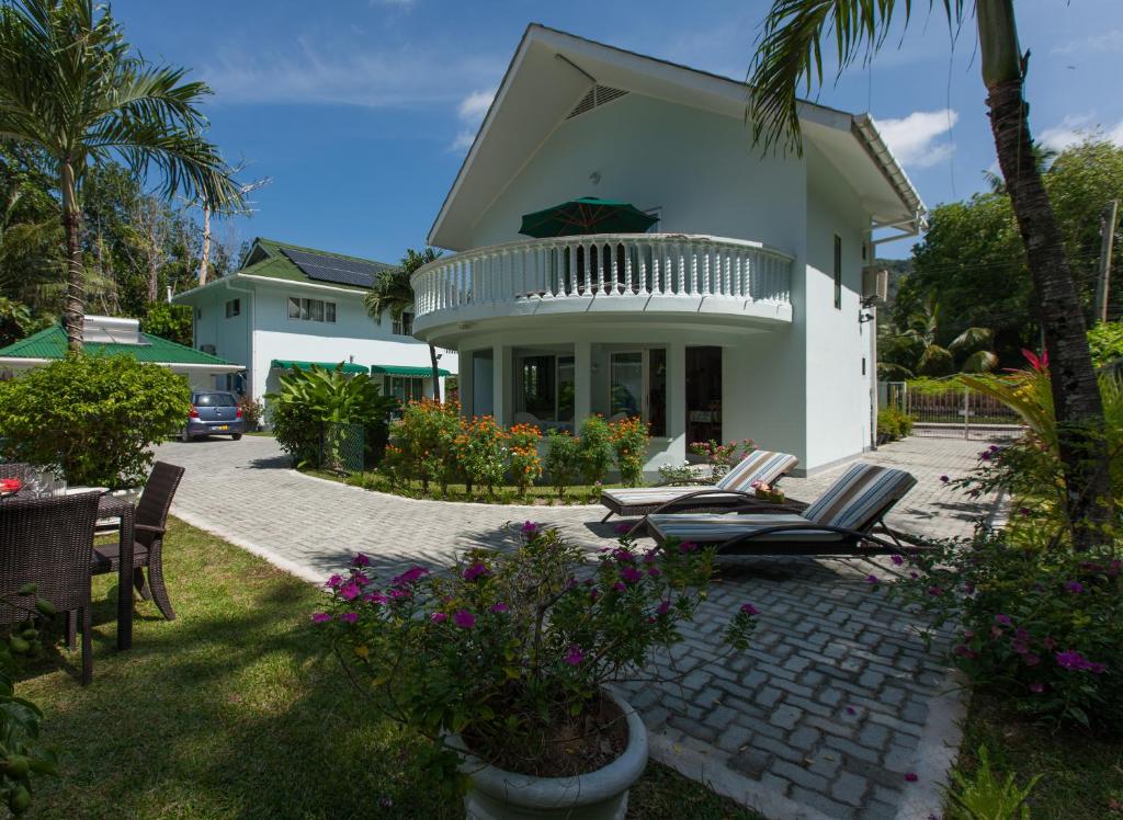 dom z krzesłami i kwiatami na dziedzińcu w obiekcie Ocean Villa w mieście Grand'Anse Praslin