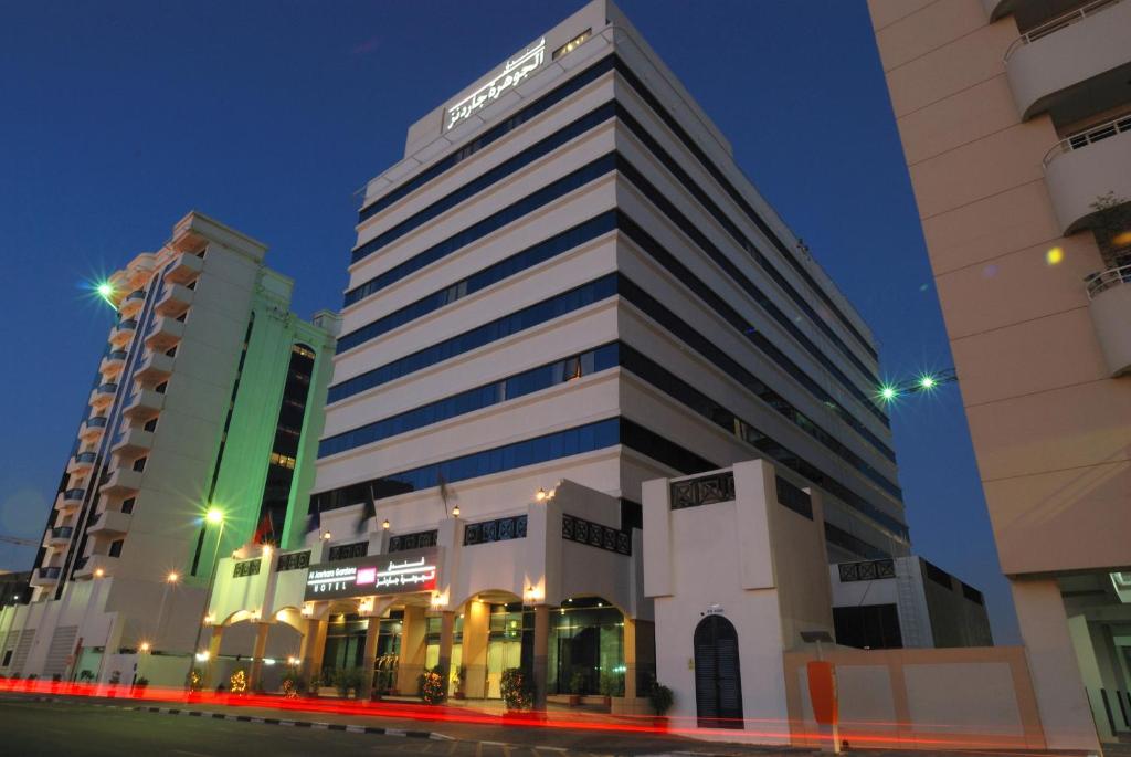 Un grand bâtiment avec un panneau en haut dans l'établissement THE PARK HOTEL Formerly Al Jawhara Gardens, à Dubaï