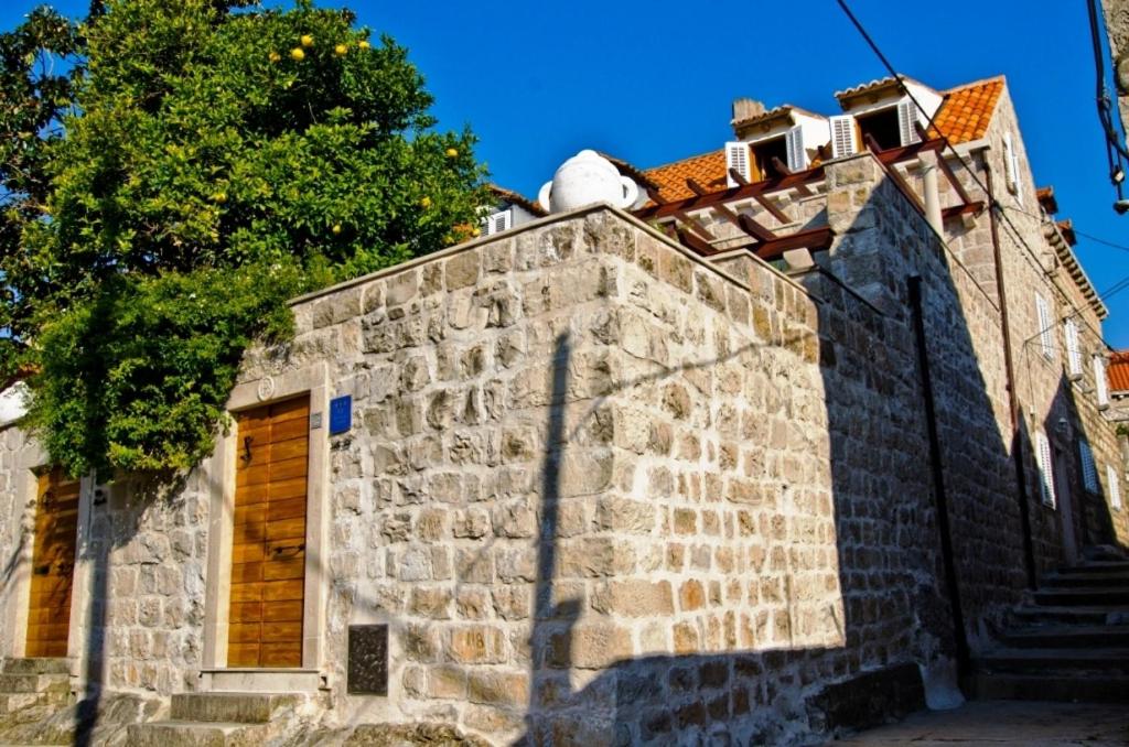 um velho edifício de pedra com uma árvore em cima dele em Villa Sole em Cavtat