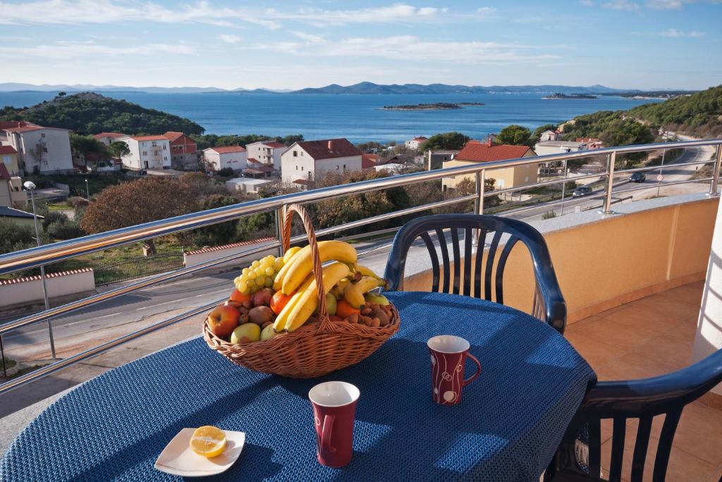 un cesto di frutta su un tavolo sul balcone di Apartments Mara a Drage