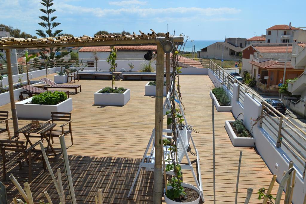 un balcón con plantas en macetas en el techo en Sempreverde Atelier B&B, en Punta Secca