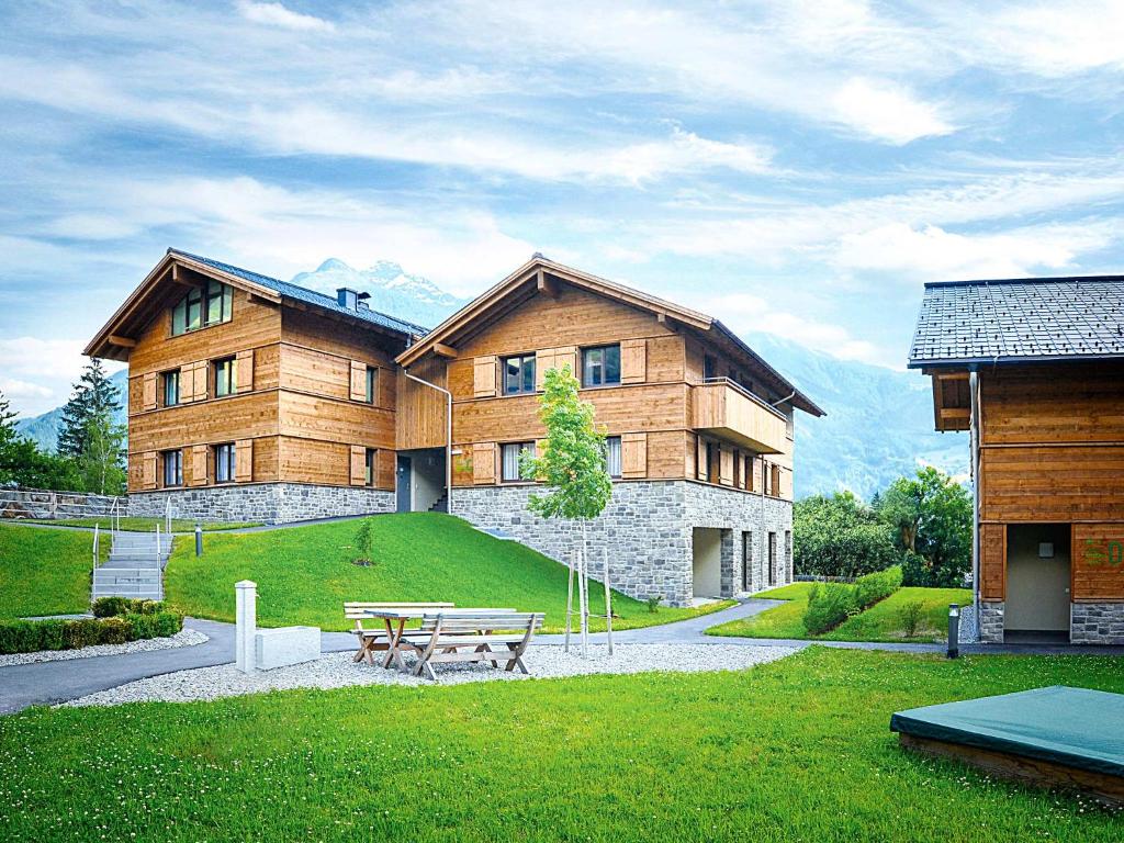 ein großes Holzgebäude mit einem Picknicktisch davor in der Unterkunft AlpinLodges Matrei in Matrei in Osttirol