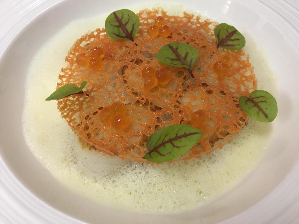 a plate of food with orange sauce and green leaves at Thalacap Île de Ré - Thalasso & Spa in Ars-en-Ré