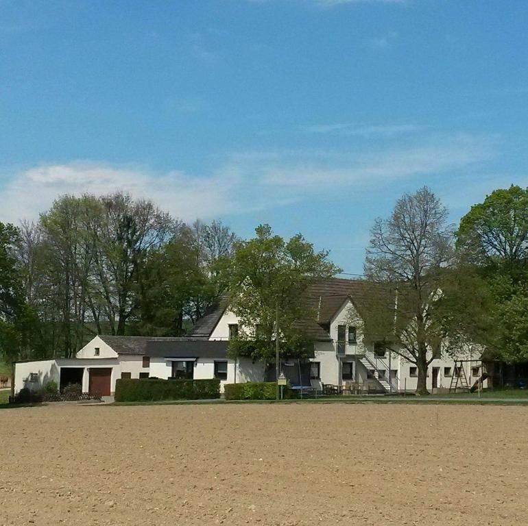 a large white house with trees in front of it at Ferienwohnung Sehnental in Bornich