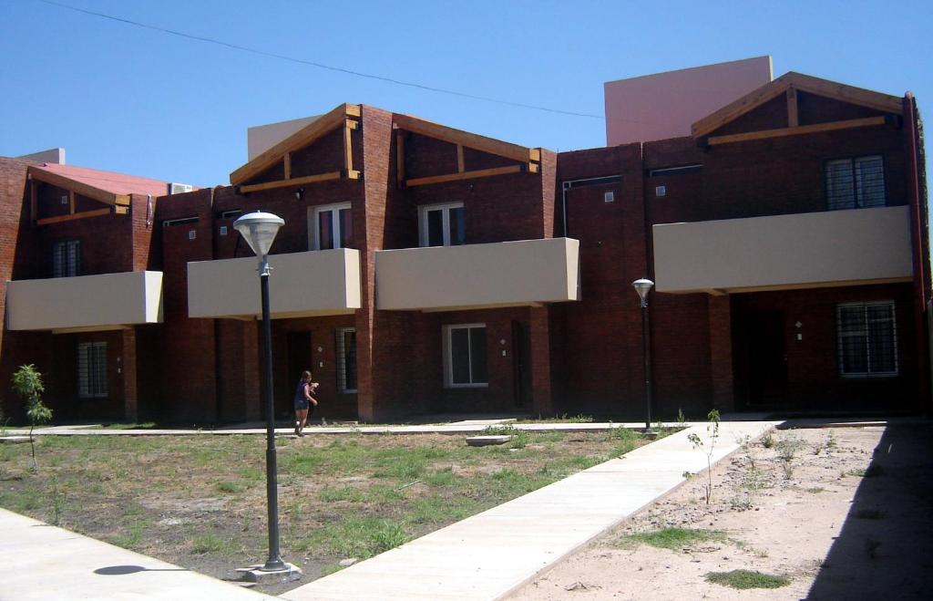 ein Gebäude mit einer Person, die davor läuft in der Unterkunft Duplex Kirara in Santa Lucía