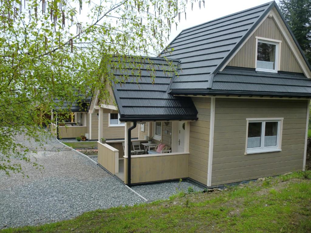 une petite maison avec un toit noir au-dessus dans l'établissement Lawendowa Dolina, à Ustroń