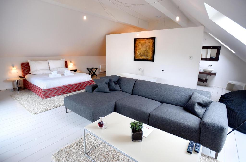 een woonkamer met een bank en een bed bij Tuddenham Mill Luxury Hotel in Tuddenham
