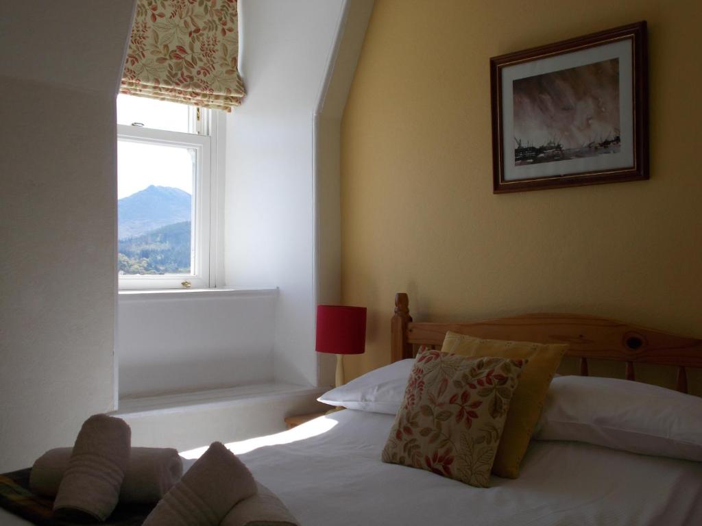 1 dormitorio con cama y ventana en Swiss Court Guest House, en Keswick