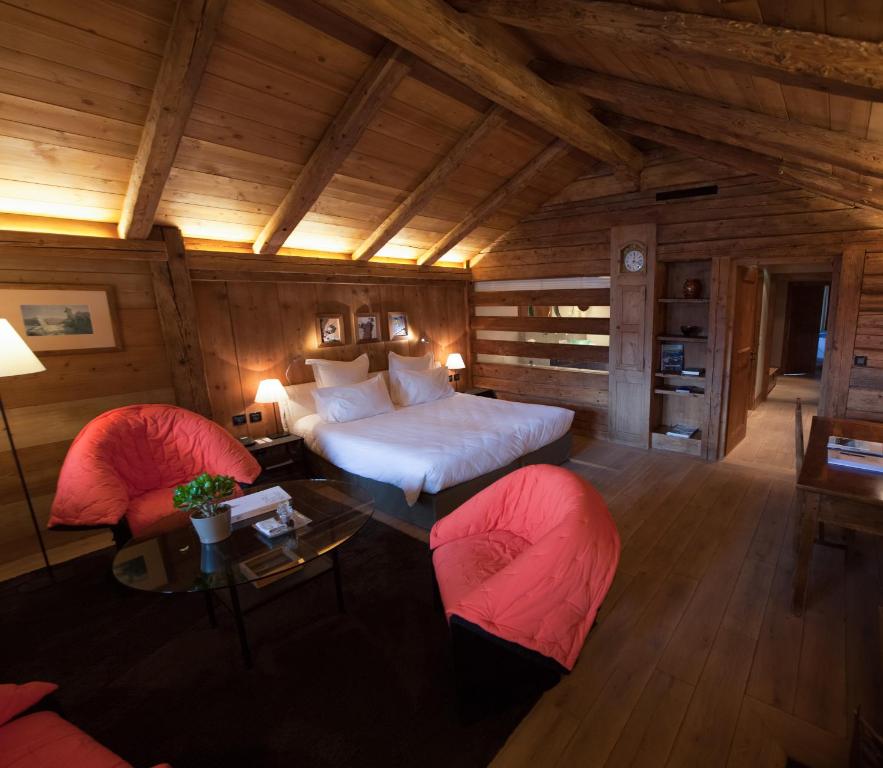 a large room with a bed and two chairs at Le Hameau Albert 1er in Chamonix