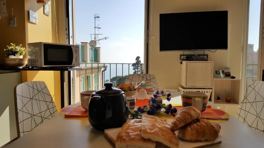 einen Tisch mit Brot und einen TV in einem Zimmer in der Unterkunft House Il Nido by Holiday World in Genua