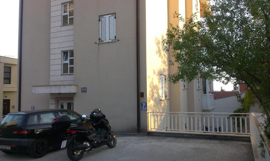 una motocicleta estacionada en un estacionamiento al lado de un edificio en Apartment Viki, en Makarska