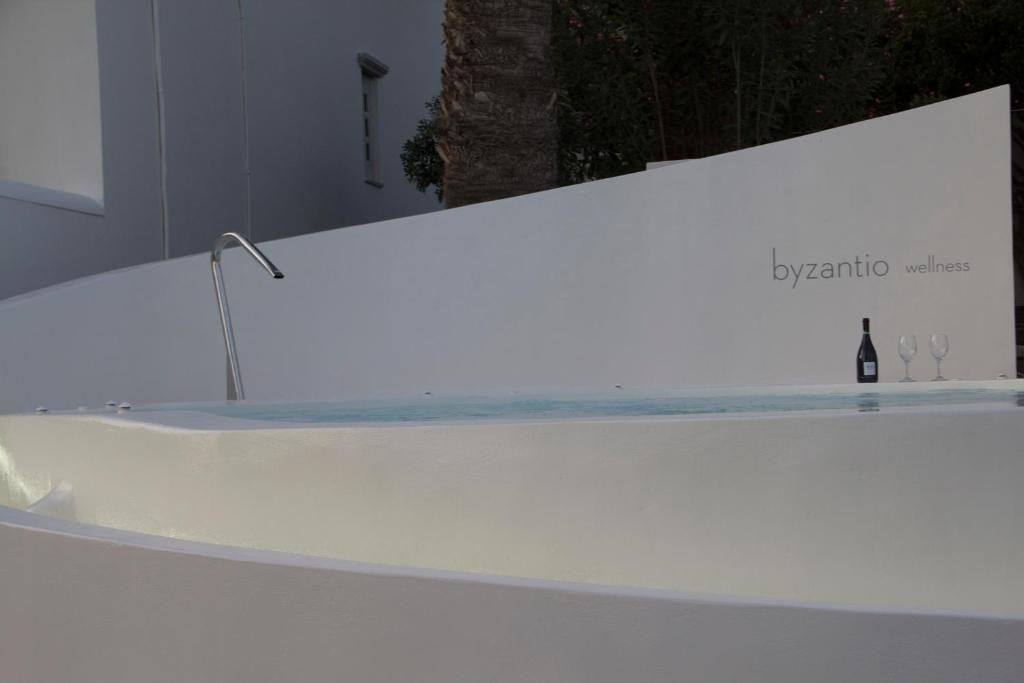a bathtub in a room with a bottle of wine at Byzantio Beach Suites & Wellness in Agios Sostis