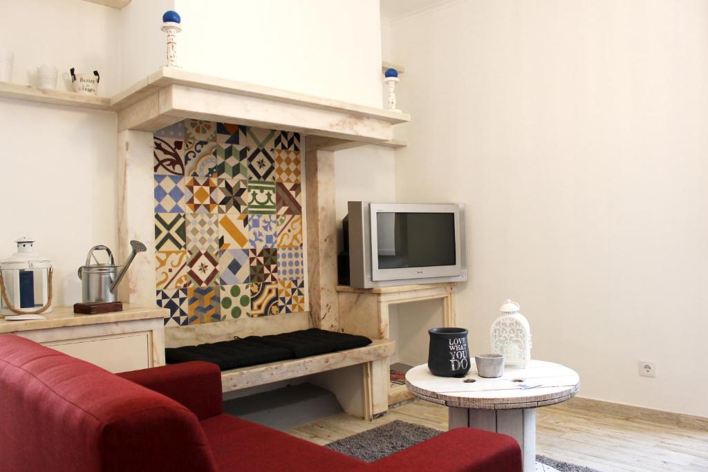 a living room with a fireplace with a tv at Origens Hostel in Sines