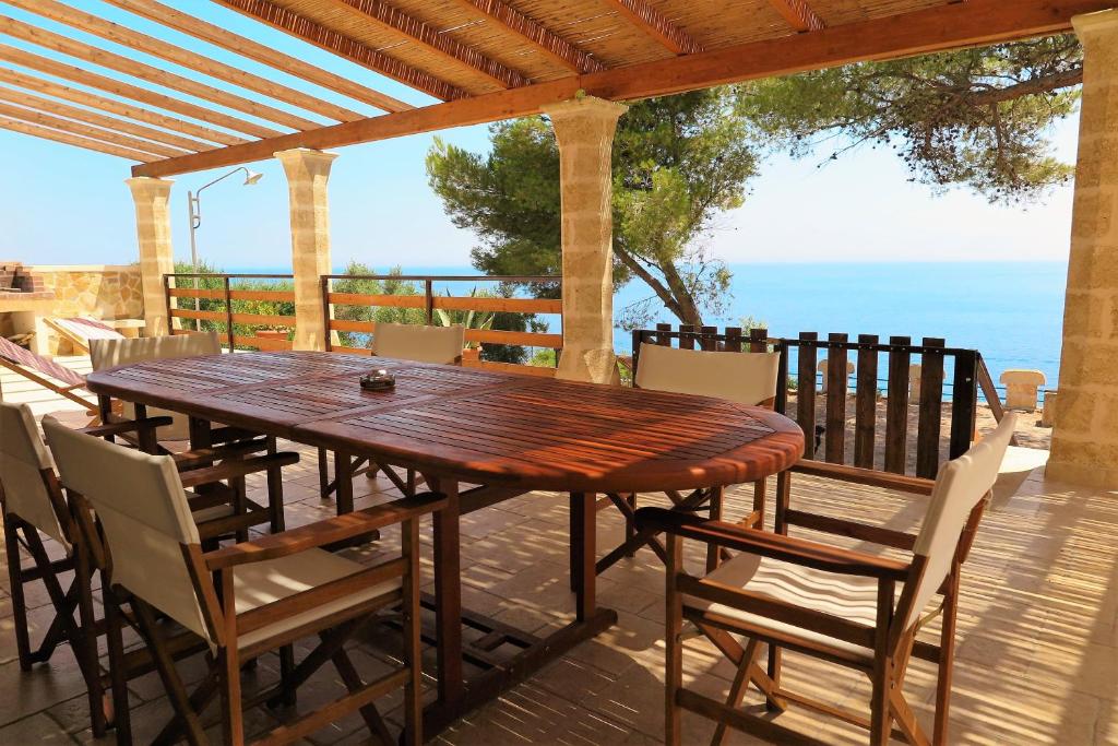 une table et des chaises en bois sur une terrasse dans l'établissement Villa Aurora, à Corsano