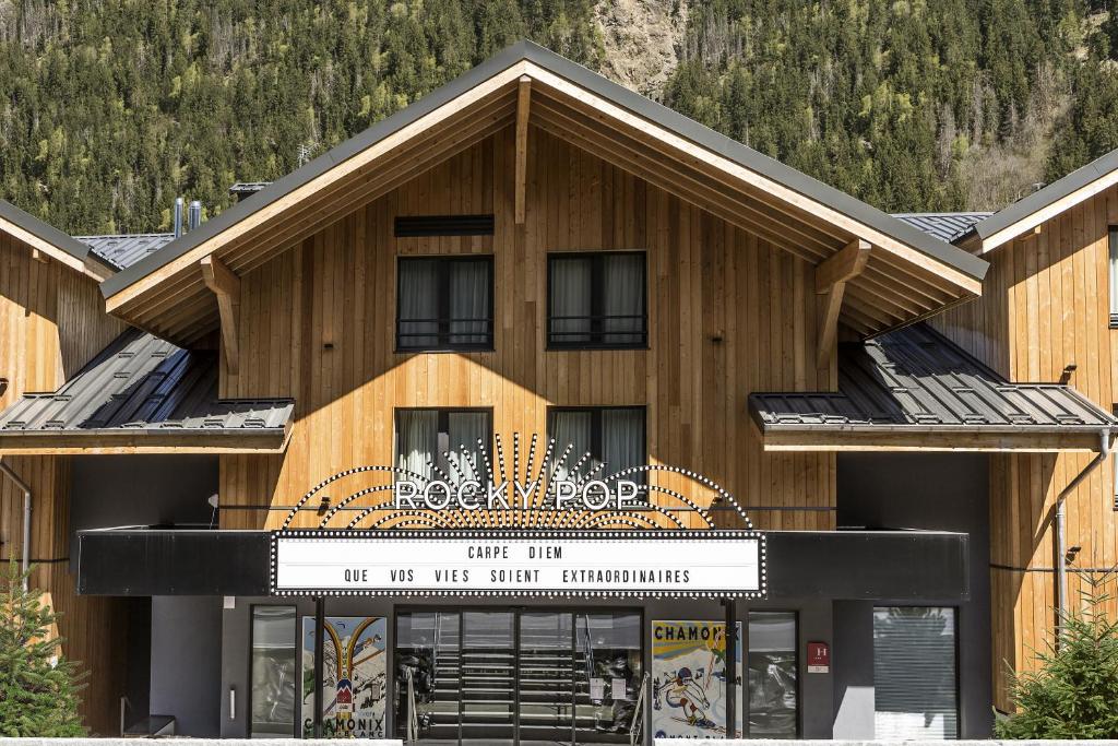 a large wooden building with a sign in front of it at RockyPop Chamonix - Les Houches in Les Houches