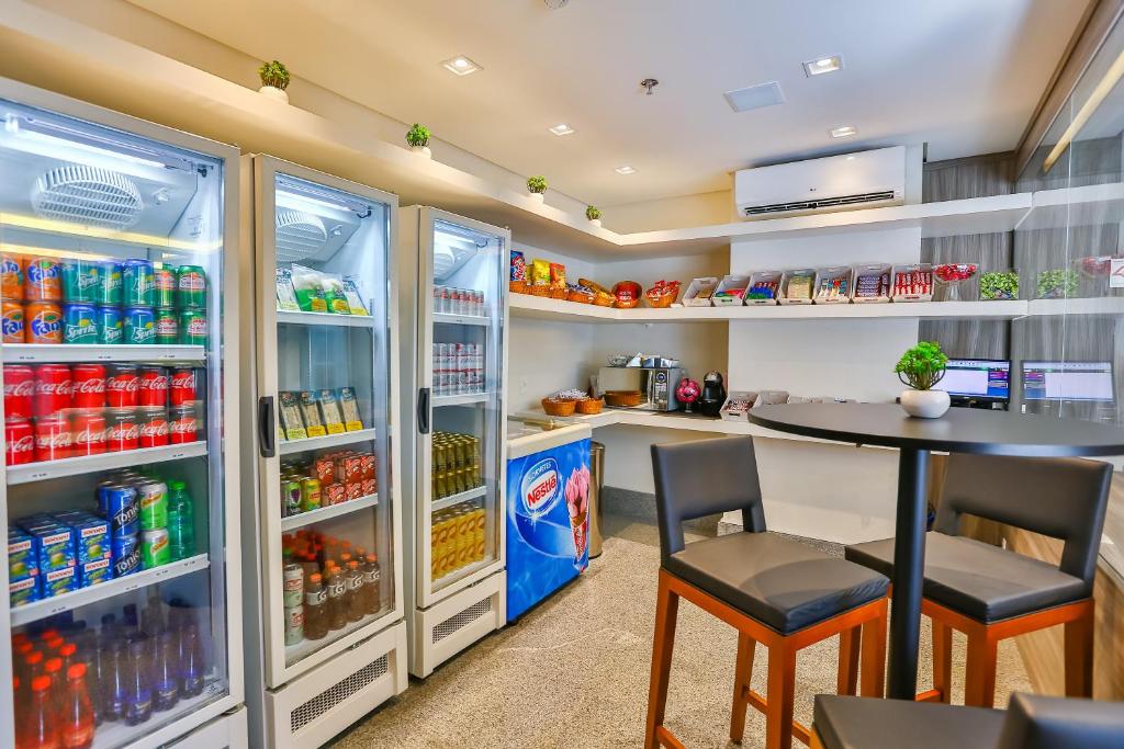 a kitchen with a table and two chairs and a refrigerator at Sleep Inn Aeroporto de Guarulhos - São Paulo in Guarulhos