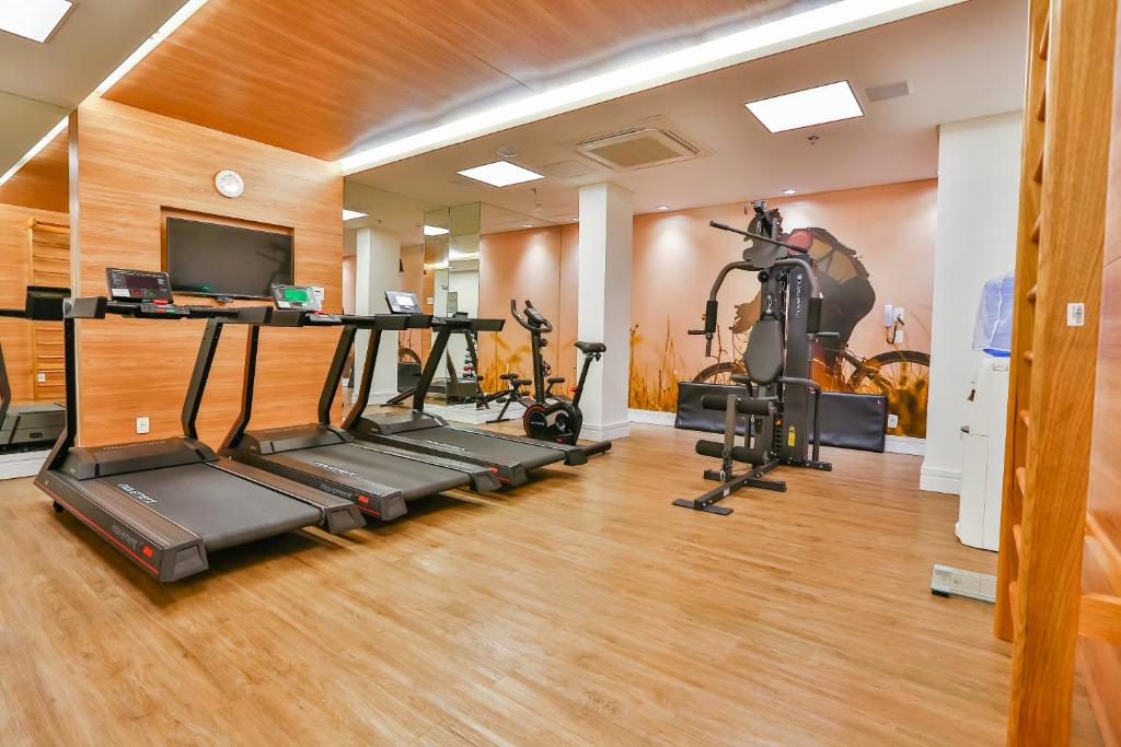 a gym with two tread machines and a television at Sleep Inn Aeroporto de Guarulhos - São Paulo in Guarulhos