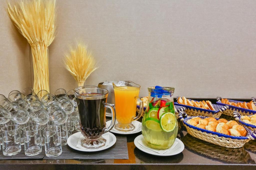 a table topped with glasses of juice and snacks at Sleep Inn Aeroporto de Guarulhos - São Paulo in Guarulhos