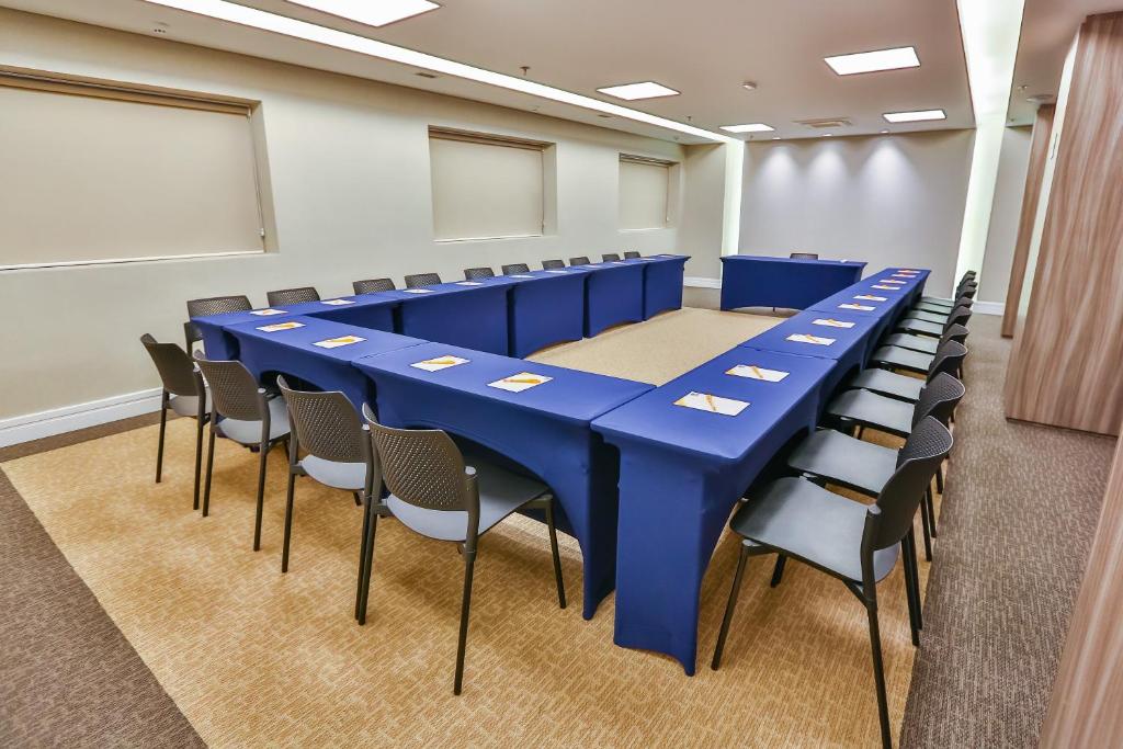 a conference room with a blue table and chairs at Sleep Inn Aeroporto de Guarulhos - São Paulo in Guarulhos