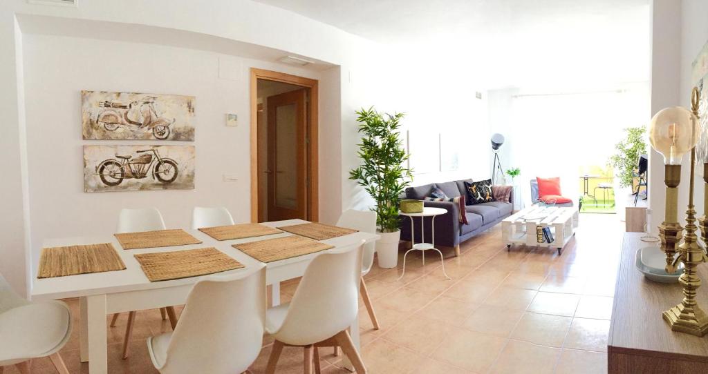 una sala de estar blanca con mesa y sillas en Apartamento EvaHome Roquetas en Roquetas de Mar