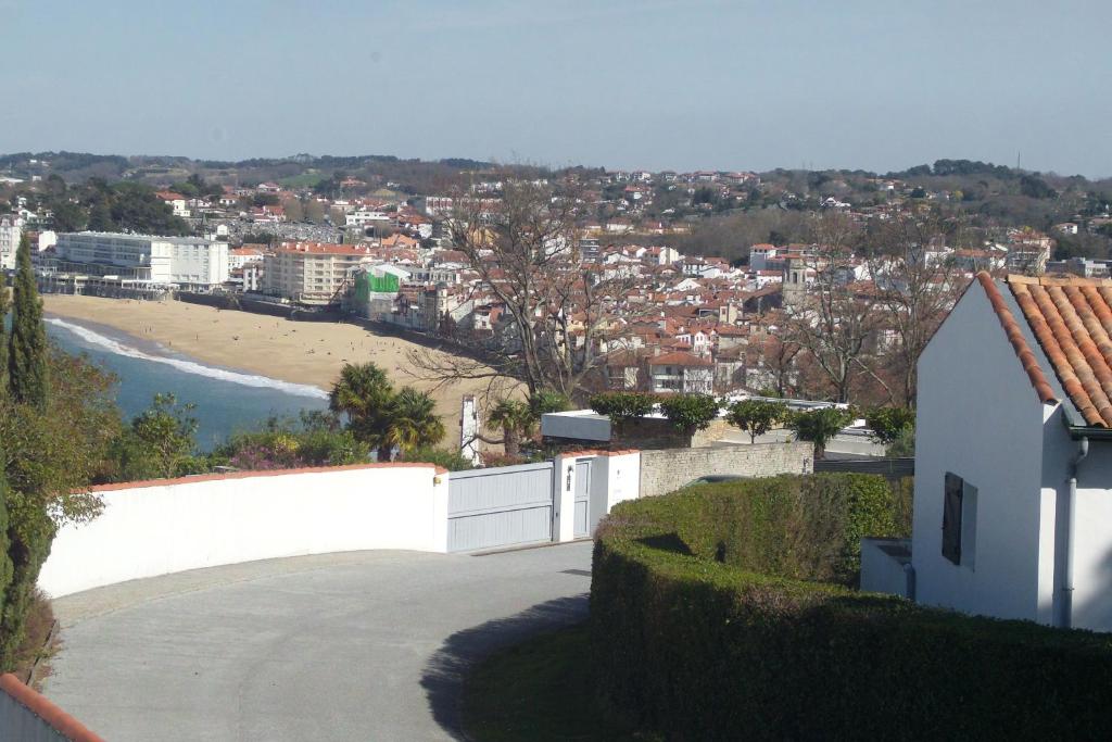 Blick auf einen Strand mit einem weißen Zaun und einem Gebäude in der Unterkunft Chambres d'hôtes GELA ITSASOA Baie in Ciboure