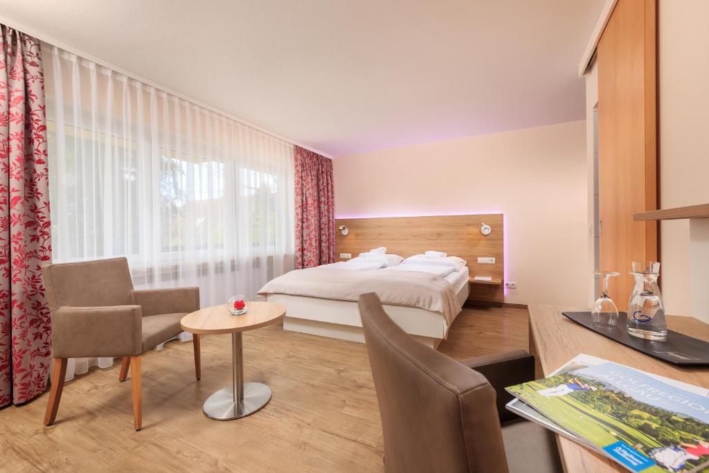 a bedroom with a bed and a table and chairs at Erkheimer Landhaus in Erkheim