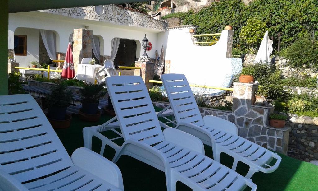 - un ensemble de chaises blanches assises sur une terrasse dans l'établissement Gologanova house, à Kalofer