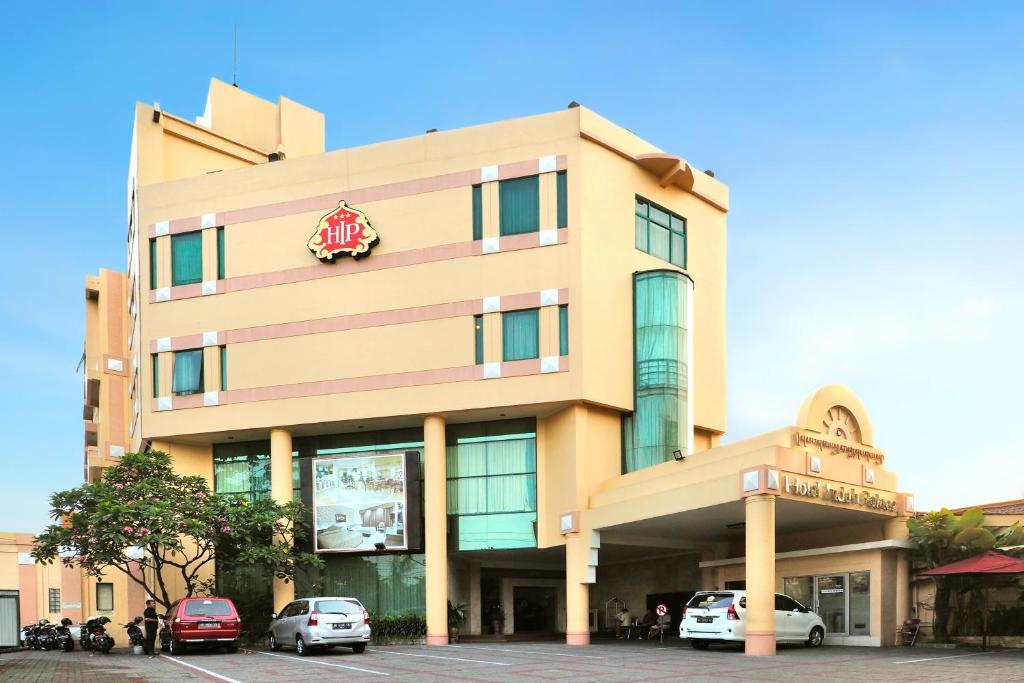 a building with cars parked in front of it at Hotel Indah Palace Solo in Solo