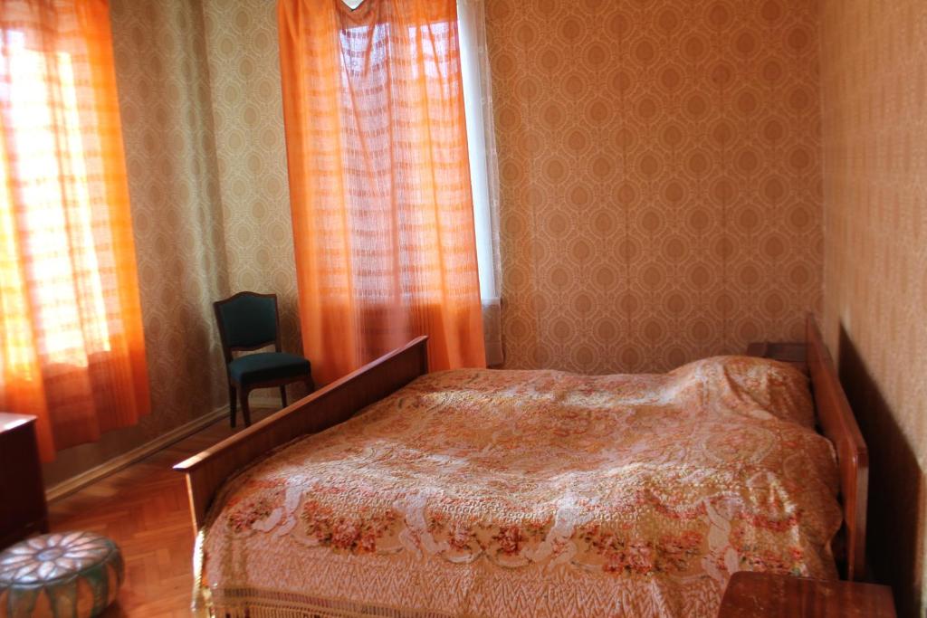 1 dormitorio con cama, ventana y silla en TLT Guest House, en Telavi