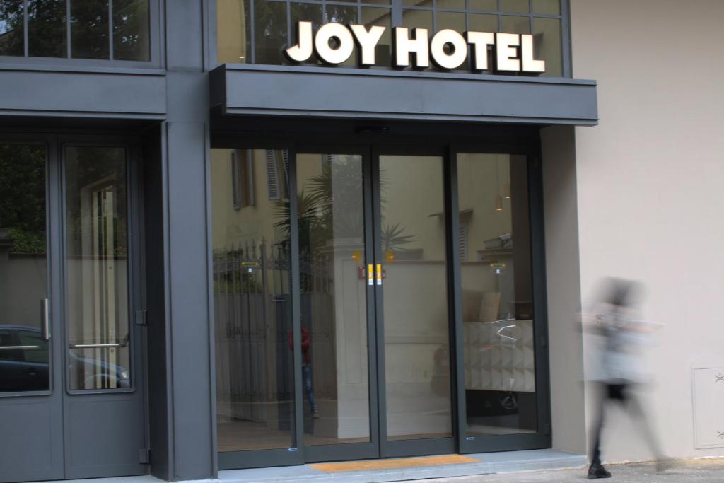 una persona caminando en frente de un edificio de hotel Joy en c-hotels Joy, en Florencia