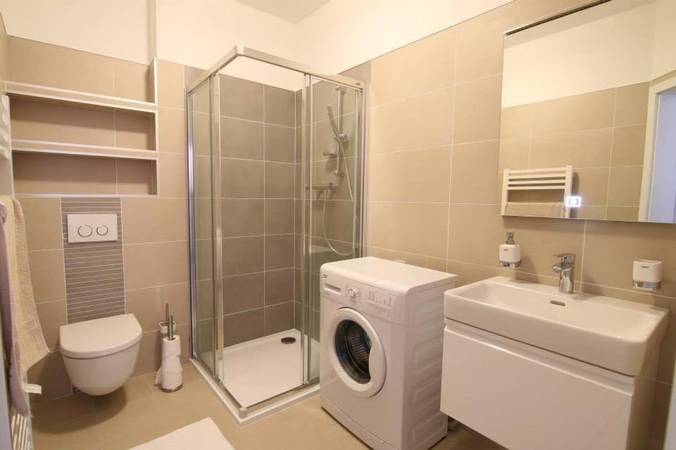 a bathroom with a washing machine and a sink at Penzion U Zamku in Jaroměřice na Rokytné