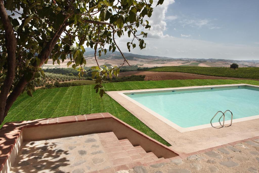 a swimming pool in a yard with a grass field at Agriturismo Il Poggione in Montalcino