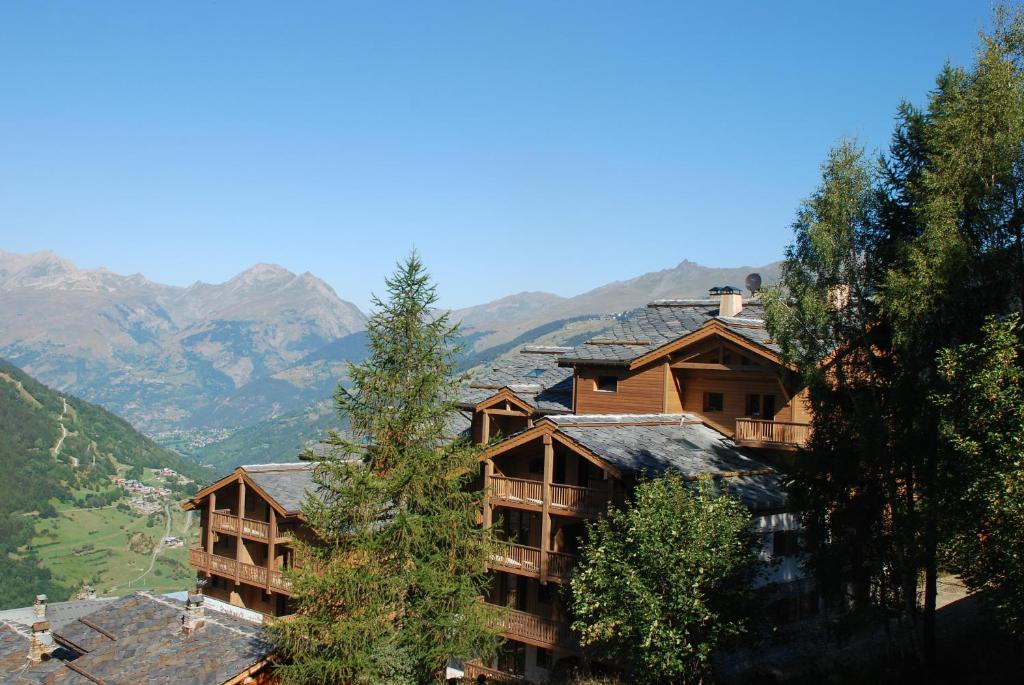 un complexe avec des montagnes en arrière-plan dans l'établissement CGH Résidences & Spas Le Ruitor, à Sainte-Foy-Tarentaise