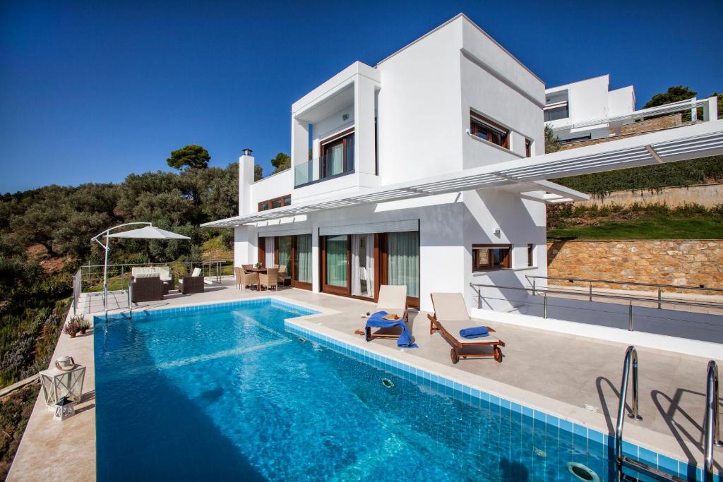uma villa com uma piscina e uma casa em Magdani Private Residences em Skiathos